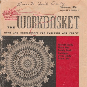 May include: The cover of Workbasket magazine, dated November 1956. It features a white crochet doily against a black background. The cover text reads "The Workbasket, Home and Needlecraft for Pleasure and Profit". The magazine lists several craft projects, including a wreath doily, place mat, paddy duck cardigan, daisy doily, and towel set. The price is 15 pence.