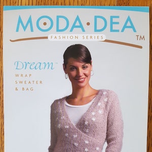 Pode incluir: Padrão da série Moda Dea Fashion para um suéter e uma bolsa Dream Wrap. O padrão apresenta uma mulher usando um suéter rosa claro com estrelas brancas bordadas e jeans azuis.