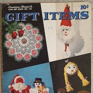 May include: A vintage craft book cover featuring crocheted gift items. The cover shows a crocheted doily, a Santa Claus ornament, a snowman ornament, and a doll ornament. The book title is "Gift Items" and the price is 10 pence.