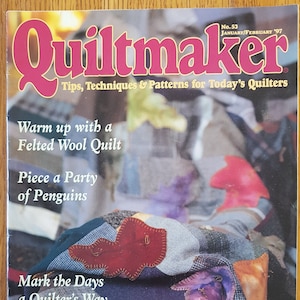 Puede incluir: Una portada de revista para Quiltmaker, una publicación para acolchadores. La portada presenta una colcha hecha de retazos de tela coloridos, con el título "Quiltmaker" en letras grandes, negritas y rosas. El texto "Consejos, técnicas y patrones para los acolchadores de hoy" está debajo del título. La portada también presenta el texto "Calienta con una colcha de lana felpuda", "Arma una fiesta de pingüinos" y "Marca los días a la manera de un acolchador".