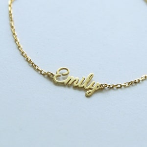 May include: A gold chain bracelet with the name "Emily" spelled out in cursive.