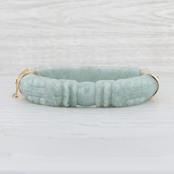 Lot 37 - A CARVED JADE BANGLE, gold mounts with