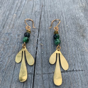 May include: Gold earrings with green gemstone beads and a teardrop-shaped design.