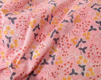 May include: Pink fabric with a floral print featuring small yellow flowers, red berries, and dark gray leaves.