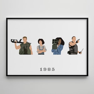 May include: A framed art print with four illustrated figures, each depicted with a weapon or device. The figures are set against a white backdrop, with the year "1985" printed in grey below. The artwork is enclosed within a black frame.