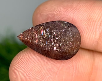 Naturalny, krwistoczerwony kamień słoneczny iolit o masie 8,35 karatów, 18,5 x 11,6 mm, w kształcie gruszki, z wieloma brokatami, lśniący, fasetowany kamień szlachetny do biżuterii