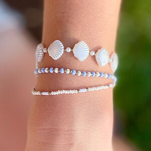 Summer Beach Jewelry Collection Stackable Stretch Bracelet Set White Shell Bead Design Coastal Boho Style Seed Pearl Ocean Inspired Nautical Armband Seashell Gold Beaded Wrist Stack Three Piece Set Light Blue Accent Perfect Vacation Gift