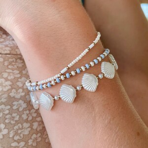 Stackable Stretch Bracelet Set Three Piece Collection White Shell Bead Jewelry Blue Summer Beach Style Coastal Boho Seed Pearl Design Ocean Inspired Nautical Armband Seashell Gold Copper Accent Beads Perfect Vacation Accessory Wrist Stack