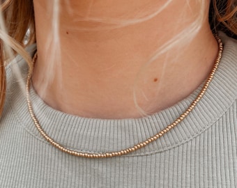 Halsband med guldfröpärlor Fina lager-på-lager-smycken för kvinnor Minimalistiskt guldchoker Delikat handgjort bohohalsband Matt guldhalsband med pärlor