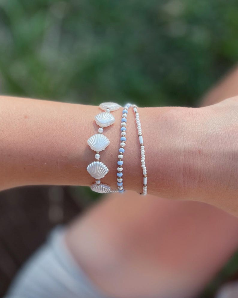 White Shell Bead Jewelry Collection Stackable Stretch Bracelet Set Blue Summer Beach Style Coastal Boho Design Seed Pearl Ocean Inspired Nautical Armband Seashell Gold Copper Accent Three Piece Wrist Stack Perfect Beach Vacation Accessory