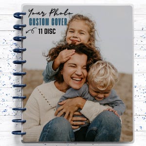 May include: A disc-bound notebook featuring a custom photo cover of a smiling family. The cover displays the text Your Photo CUSTOM COVER 11 DISC. The notebook is held together by eleven dark blue plastic discs along the left side, providing a secure binding for the pages within this personalized stationery item.
