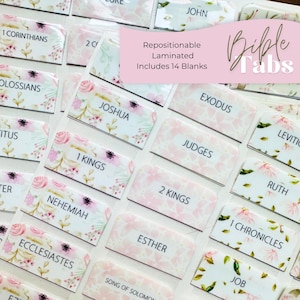 May include: A collection of repositionable laminated Bible tabs featuring a floral pattern in shades of pink and green. The tabs are printed with book names such as Exodus, Joshua, Judges, and 1 Kings, and include 14 blank tabs for customization.