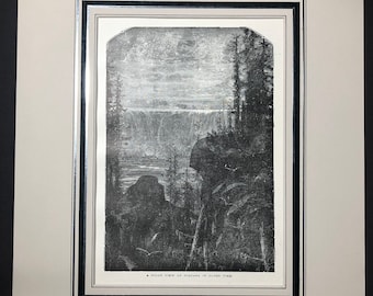 May include: Black and white print of Niagara Falls at night, framed with a white mat and black frame. The image depicts the falls cascading over a cliff, with trees and a dark sky. Text at the bottom reads "A NIGHT VIEW OF NIAGARA IN OLDEN TIME."