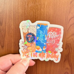 May include: A holographic sticker featuring illustrations of a Seven Brew coffee cup, an Alani Nu energy drink can, and a Dr. Pepper can. The text "Yes, I've ate today" is printed in orange at the bottom, surrounded by small star shapes.