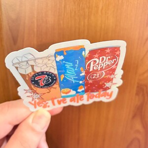 May include: A die-cut sticker featuring three beverage containers: a Seven Brew iced coffee with ice cubes, a blue Alani Nu energy drink, and a red Dr. Pepper can. The sticker includes the text "Yes, I've ate today" in orange script at the bottom.