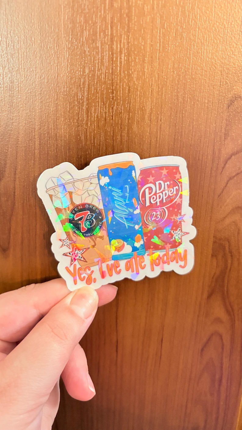 May include: A holographic sticker featuring a Seven Brew coffee cup, a blue Alani Nu energy drink can, and a red Dr. Pepper can. The sticker includes the text 'Yes, I've ale today' in orange script at the bottom, accented with small star shapes.