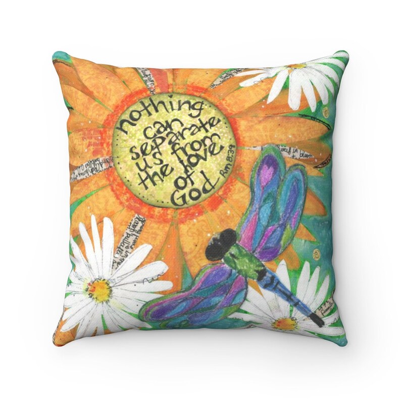 May include: Square throw pillow with a colorful floral design. The pillow features a large orange sunflower, white daisies, and a dragonfly with blue and purple wings. Text on the pillow reads "nothing can separate us from the love of God."