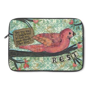 May include: A laptop sleeve with a watercolor painting of a bird perched on a branch. The background is a teal and gold damask pattern. The bird is pink and has a black eye. The branch is brown and has a sign hanging from it that says "Yes my soul finds rest in God, my hope comes from Him. Ps 62:5". The sign is white with black lettering. The word "REST" is written in black letters on a white background and is hanging from the branch.