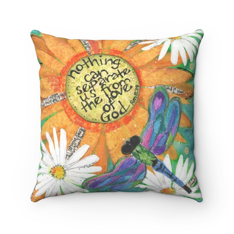 May include: Square throw pillow with a colorful floral design. The pillow features a large orange flower with the text "nothing can separate us from the love of God" and a dragonfly. White daisies are scattered around the design.