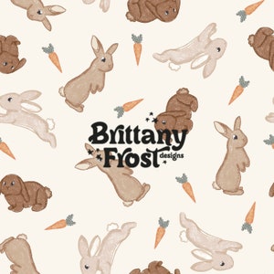Peut inclure: Un motif sans couture représentant des lapins bruns et beiges avec des illustrations de carottes. Le motif comprend le texte "Brittany Frost designs".