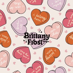May include: A pattern of pink, orange, and purple heart-shaped candies with various positive affirmations written on them. The text includes phrases like "I can do this", "I love myself", and "I belong here".