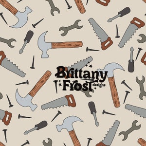Peut inclure: Un motif sans couture représentant divers outils, dont des marteaux, des tournevis, des clés et des scies, tous dans des tons de brun, gris et noir. Le fond est de couleur beige clair. Le texte "Brittany Frost designs" est centré dans le motif.