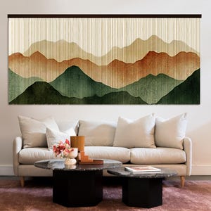 Puede incluir: Un tapiz rectangular grande con un estampado de paisaje montañoso en capas. El diseño muestra bandas horizontales de color que transicionan desde un verde bosque oscuro en la base hasta tonos terracota, bronceado y crema en la parte superior.