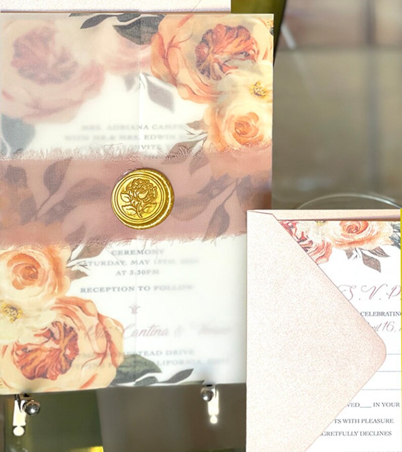 Puede incluir: Elegante juego de invitaciones de boda con dise&ntilde;os florales en tonos melocot&oacute;n y crema. La invitaci&oacute;n incluye un sello de cera dorado y una cinta rosa suave. El texto de la invitaci&oacute;n dice "Mrs. Adriana Camp...Invite".
