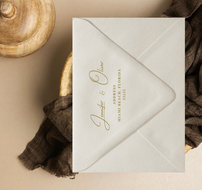 Puede incluir: Un sobre color crema con los nombres "Jennifer & Oliver" en elegante escritura dorada. La direcci&oacute;n est&aacute; impresa debajo, con la ciudad y el estado de Miami Beach, Florida, y el c&oacute;digo postal 33133.