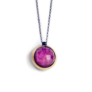 Può includere: Una delicata collana a catena d'argento con un ciondolo rotondo che presenta una pietra preziosa viola scuro incastonata in una ghiera d'oro.