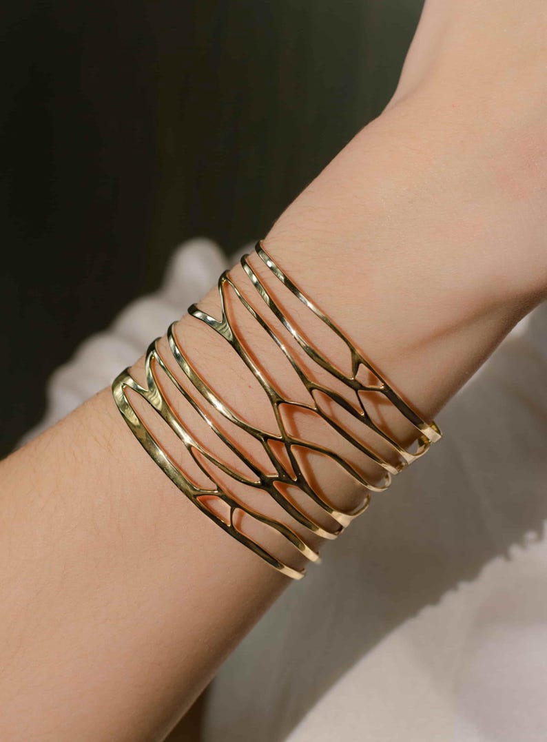 A woman wears a brass Bracelet 'Branching' with detailed natural motifs, a stylish gift idea for women who love organic and sculptural jewelry.
