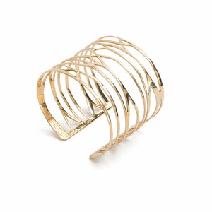 Wide cuff bracelet in brass metal with branching lines, a modern take on classic women's silver jewelry.