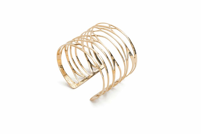 Wide cuff bracelet in brass metal with branching lines, a modern take on classic women's silver jewelry.