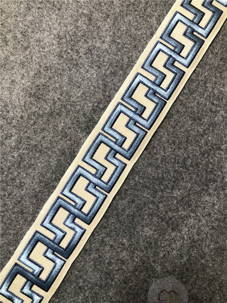 May include: Beige trim with a blue geometric pattern. The trim has a raised, embroidered design.