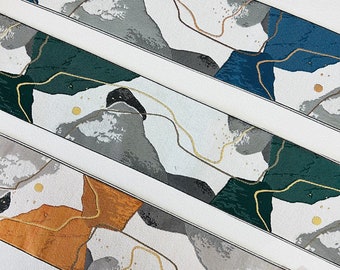 Pode incluir: Faixas de tecido com padrões abstratos em tons de azul, verde, cinza e laranja, com detalhes de linhas douradas. O design assemelha-se a uma paisagem ou mapa estilizado. As faixas são delimitadas por linhas brancas.