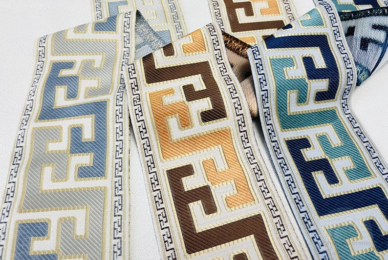 Pode incluir: Quatro guarni&ccedil;&otilde;es diferentes com um padr&atilde;o geom&eacute;trico em tons de azul, castanho, dourado e branco. As guarni&ccedil;&otilde;es s&atilde;o tecidas com uma textura em relevo.