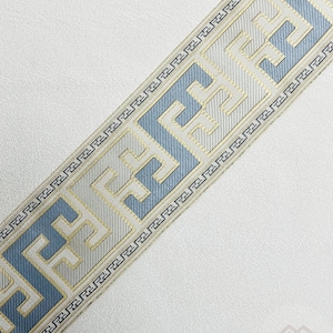 Pode incluir: Uma guarni&ccedil;&atilde;o branca e azul com um design geom&eacute;trico. A guarni&ccedil;&atilde;o apresenta um padr&atilde;o repetido de um motivo de chave grega.