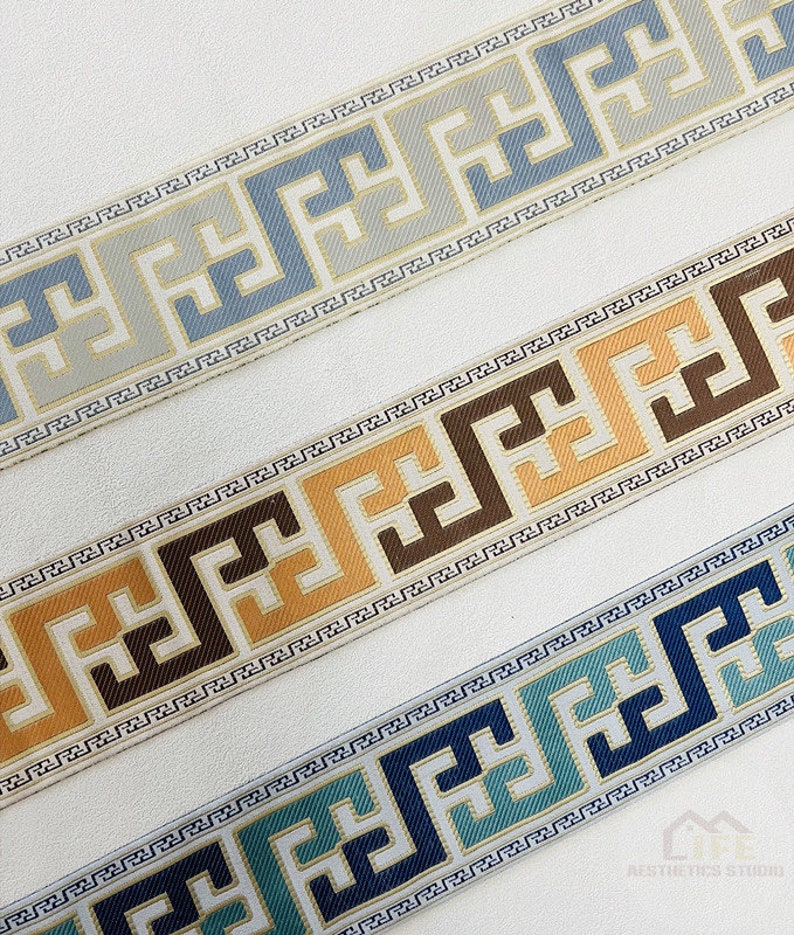 Pode incluir: Tr&ecirc;s diferentes guarni&ccedil;&otilde;es com um design geom&eacute;trico. As guarni&ccedil;&otilde;es s&atilde;o em tons de azul, marrom e dourado. As guarni&ccedil;&otilde;es est&atilde;o sobre um fundo branco.