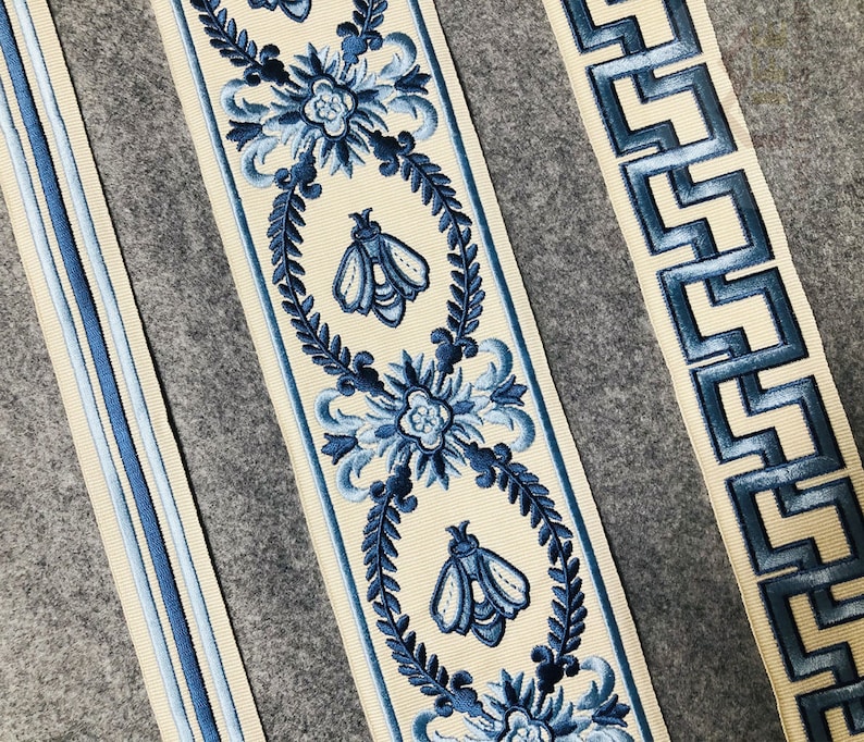 May include: Three different blue and white patterned trims with a cream background. The trims feature floral designs, bees, and geometric patterns.