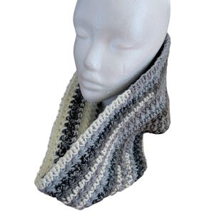 Peut inclure: Un tour de cou en crochet rayé gris, blanc et noir. Le tour de cou est réalisé avec un point texturé et est plié.