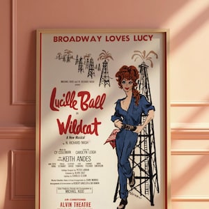 May include: Framed vintage poster for the Broadway musical "Wildcat" starring Lucille Ball. The poster features a stylized illustration of Ball in a blue jumpsuit, oil derricks, and the text "Broadway Loves Lucy."