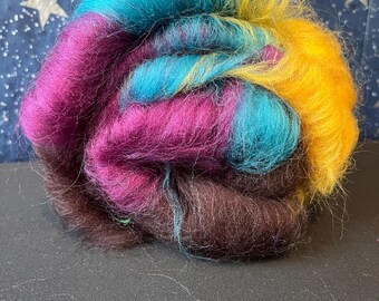 May include: A ball of colorful wool yarn in shades of brown, purple, teal, and yellow. The yarn is arranged in a spiral shape.