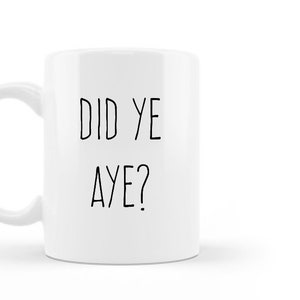 May include: White ceramic mug with a curved handle. The mug features the text "DID YE AYE?" in black, handwritten-style lettering. The mug is set against a white background.