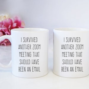 Pu&ograve; includere: Due tazze da caff&egrave; bianche con testo nero che recita "Sono sopravvissuto a un'altra riunione Zoom che avrebbe dovuto essere un'e-mail".