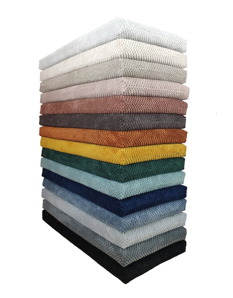 May include: A vertical stack of rectangular fabric cushions featuring a textured, raised honeycomb pattern. The collection includes a variety of colors ranging from white, cream, and beige to pink, brown, orange, yellow, green, blue, gray, and black.