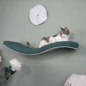Wall-mounted cat bed with invisible fastening in a wave-shaped design for large cats featuring a soft cushion and a removable washable cover