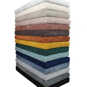 May include: A stack of 14 fabric samples in various colors, including white, beige, light pink, gray, brown, orange, yellow, green, blue, light blue, and black.