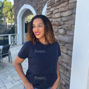 May include: A dark navy blue short-sleeved t-shirt with a horizontal seam across the chest, paired with blue denim shorts featuring a frayed, distressed hemline. The t-shirt has a simple crew neckline and a solid, plain fabric construction.