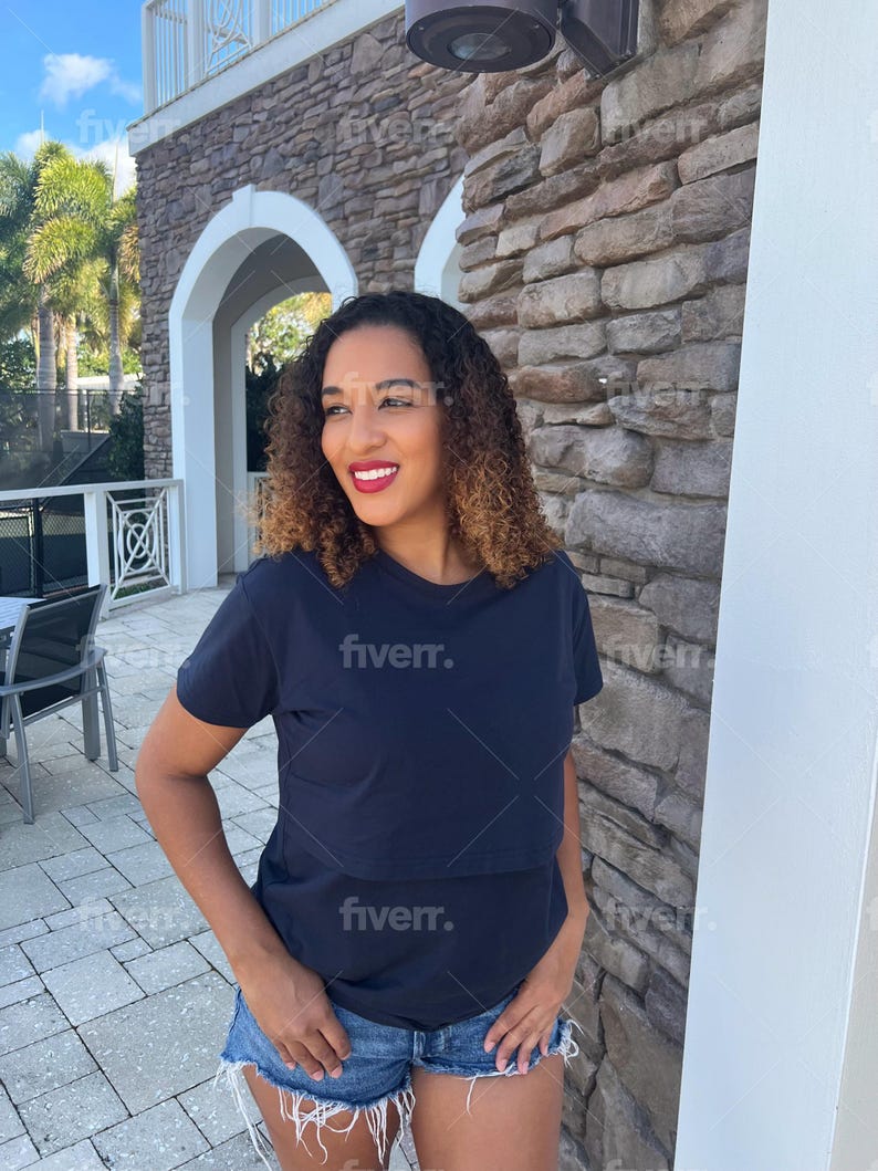 May include: A dark navy blue short-sleeved t-shirt with a horizontal seam across the chest, paired with blue denim shorts featuring a frayed, distressed hemline. The t-shirt has a simple crew neckline and a solid, plain fabric construction.