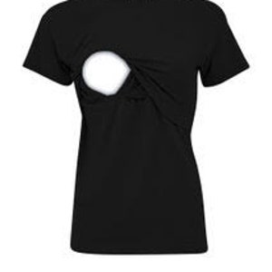 May include: A solid black short-sleeved t-shirt featuring a round neckline and a distinct circular cutout detail on the upper chest area. The garment has a plain hemline and a small white rectangular brand label attached to the inside of the collar.